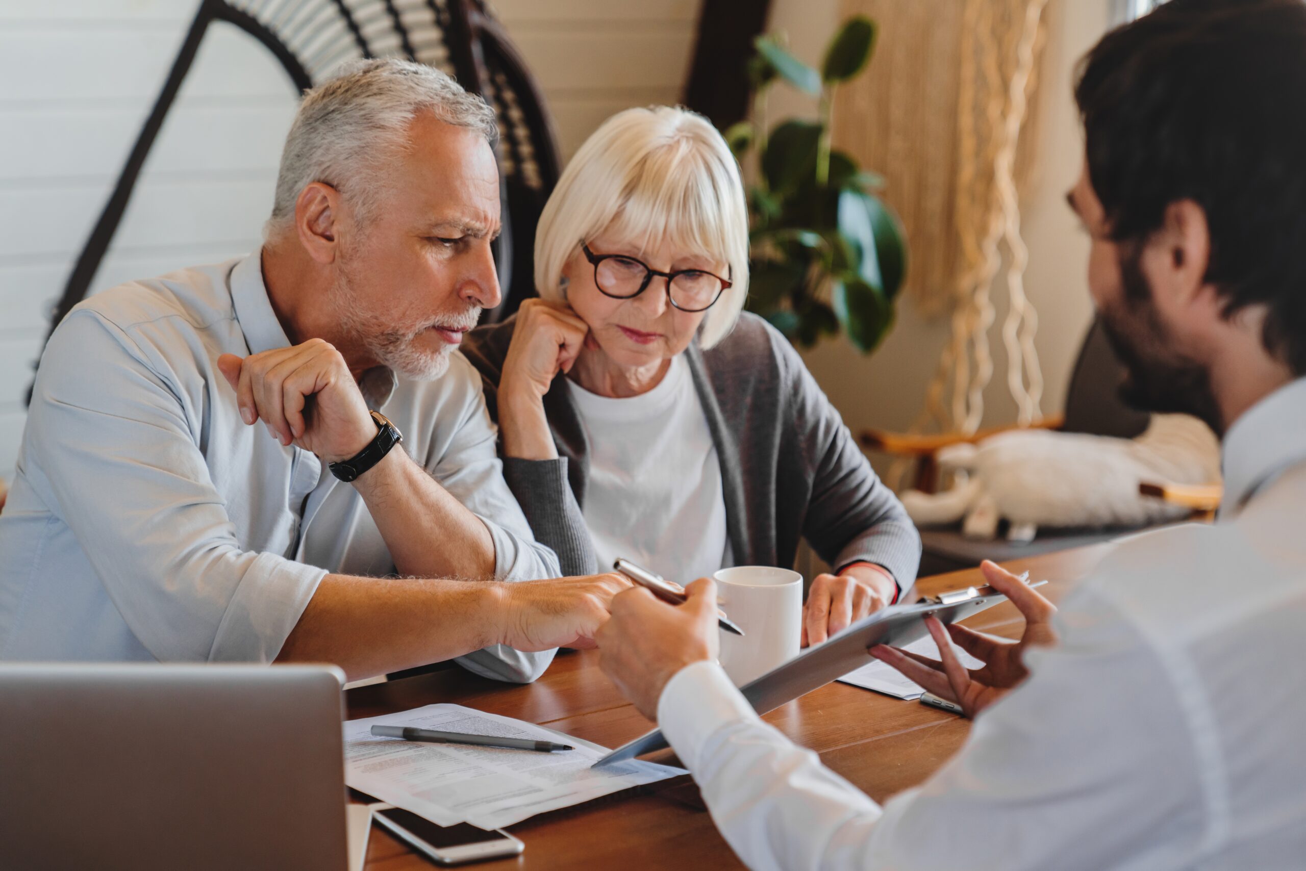 A sales consultant having an engaging meeting with two elderly clients.